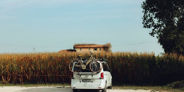 A Mercedes Marco Polo van with bike racks is parked in autumn in front of a field.