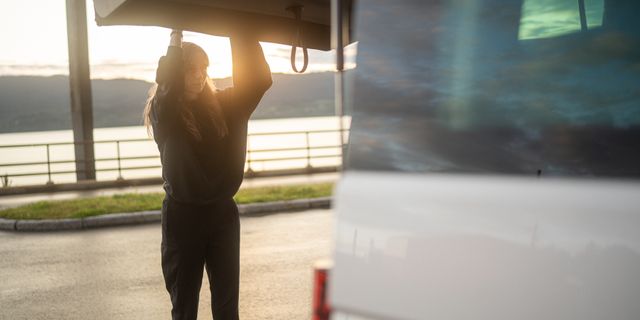 Frau macht Camper von Kofferraum zu